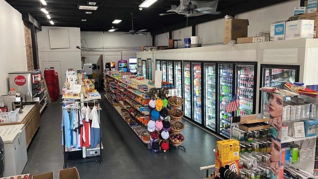 The main shopping aisle running toward the drink coolers at the back of the store.